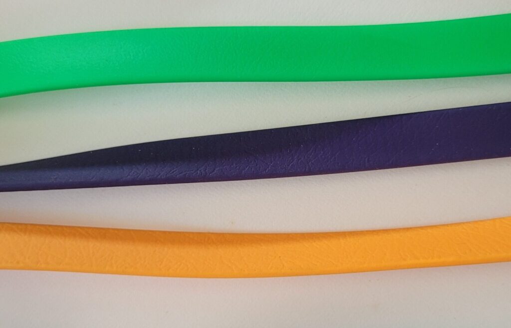 USA Biothane strap width picture: of three straps side by side, from top) 5/8 inch bright green, 1/2 inch navy, 1/2 inch pale orange,